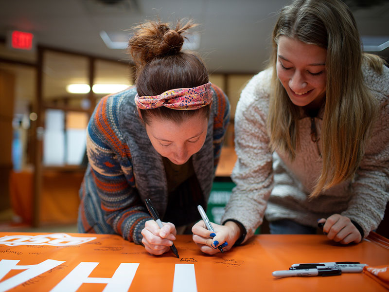 two-girls-signing-poster-800x600