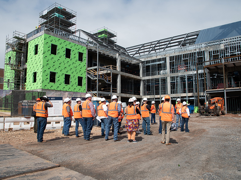 Tour participants stand on New Frontiers construction site