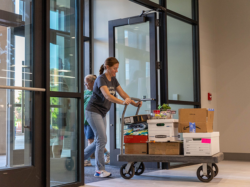 Person pushing a cart through doors of new building