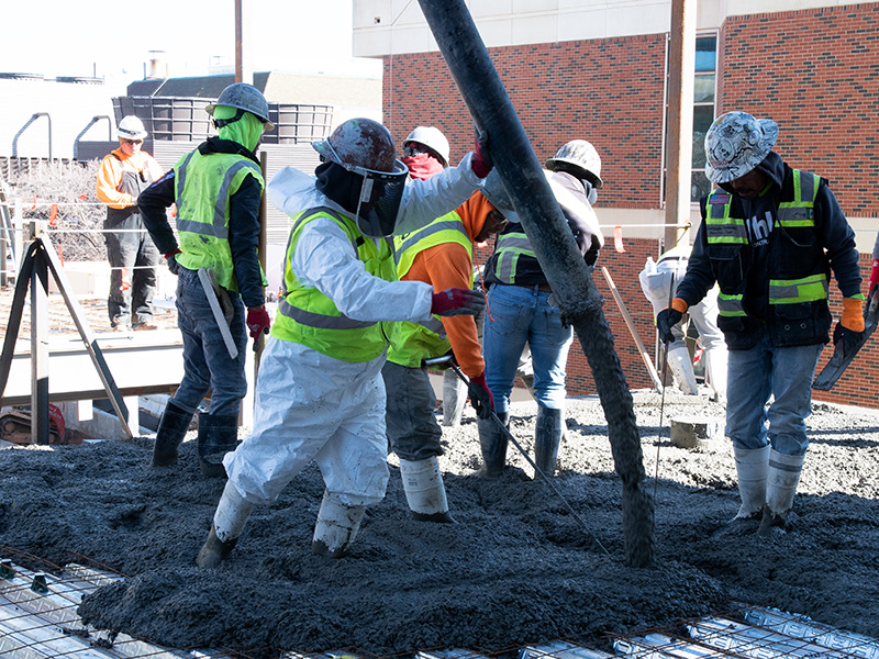 Construction workers pouring and working concrete
