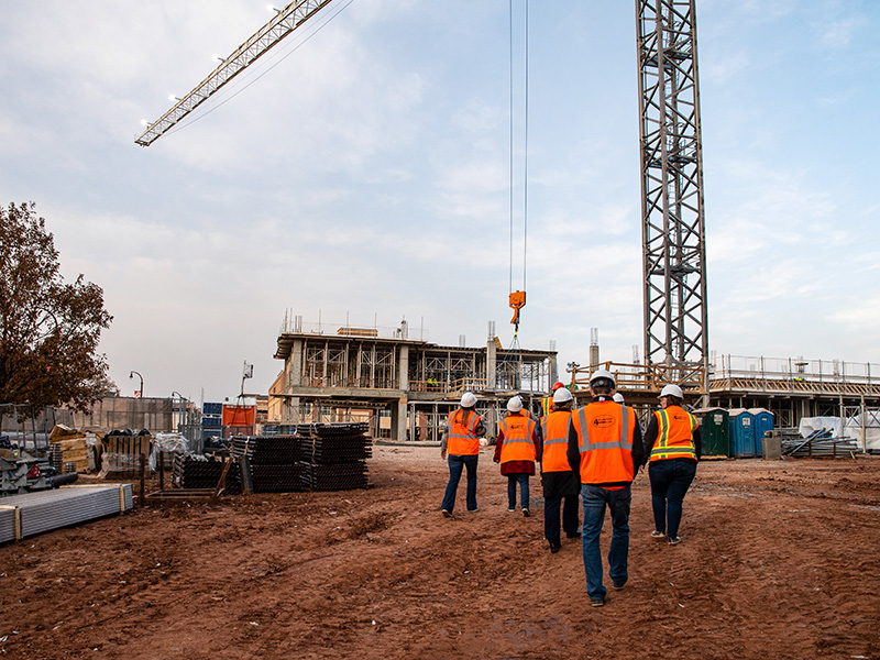 walking off construction site with crane in background